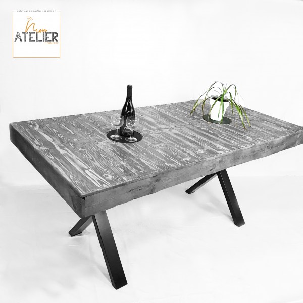 Table de salle à manger en bois de palette recyclé avec pied en acier type croix et dessous de plat incorporé, lasure et vernis de protection pour le plateau et peinture sur acier de couleur noire.